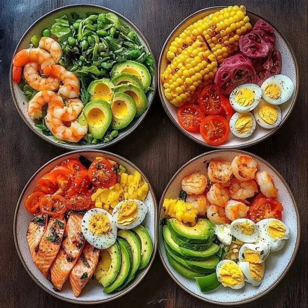 Four healthy bowls with shrimp, salmon, avocado, eggs, and fresh summer vegetables.