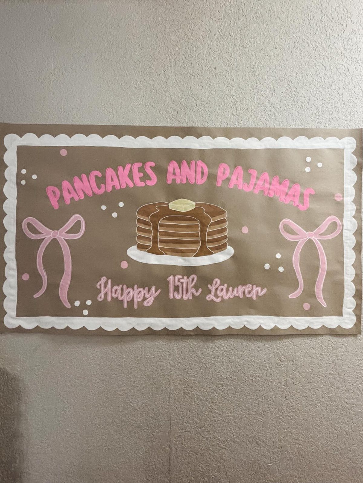 Brown party banner with pink text and a drawing of a pancake stack.