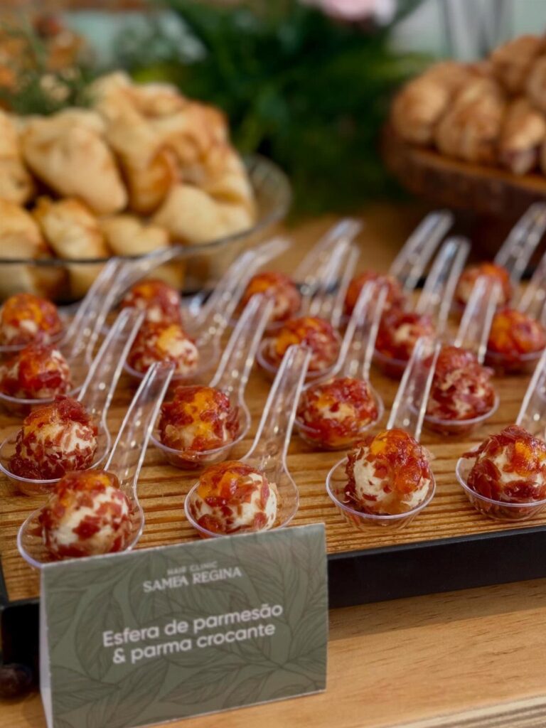 Cheese and meat appetizers in plastic spoons on a wooden party tray